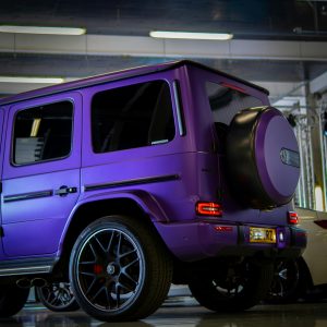 A sleek purple SUV parked indoors, showcasing its modern design and wheels.